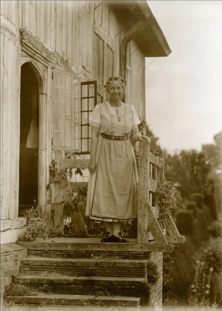 Daisy Lloyd wearing Austrian peasant costume on the steps of the Yeomans hall