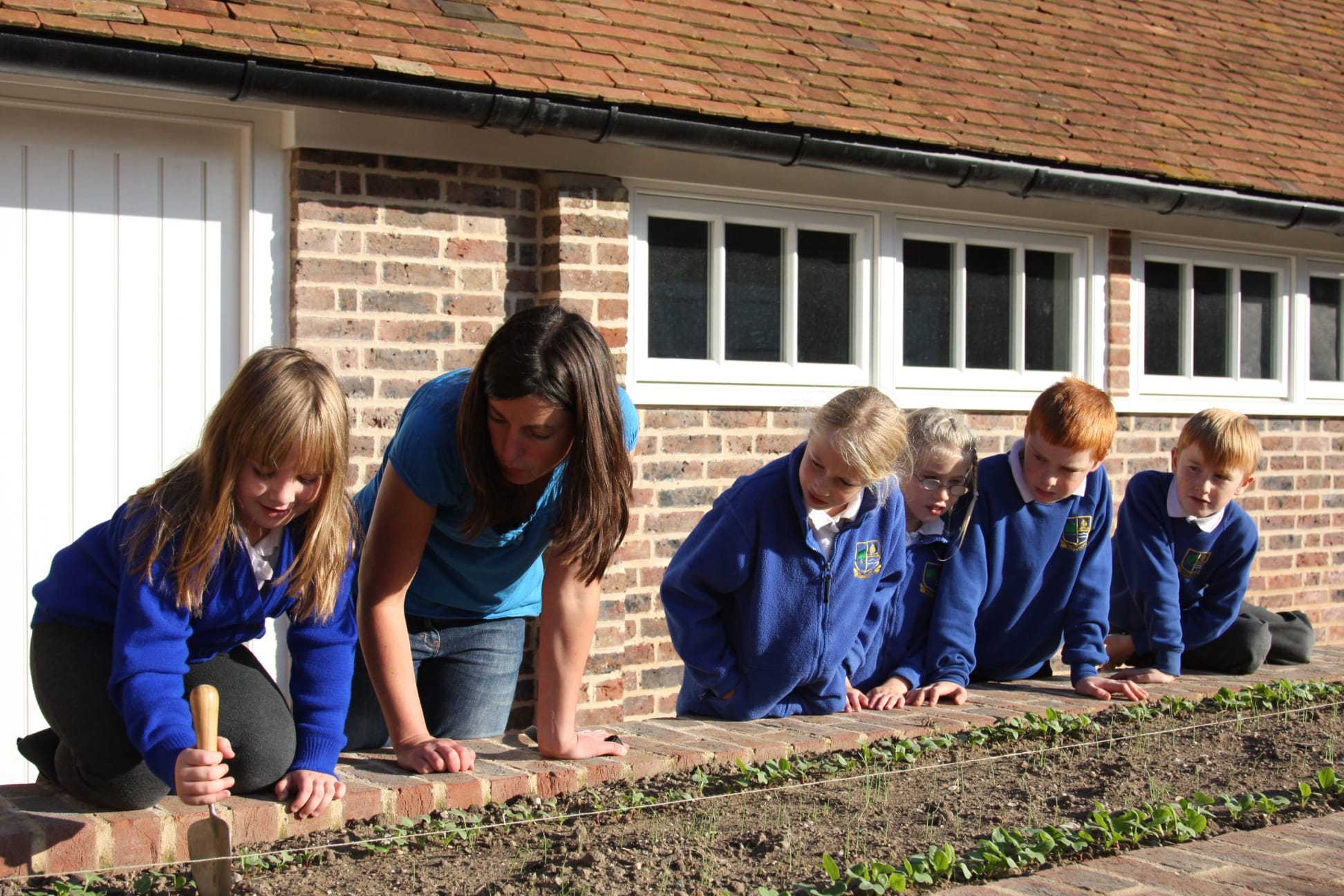 Children planting in the garden in the teaching garden at Dixter Farm 